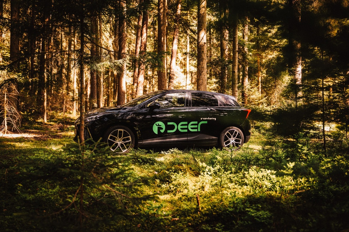 A deer electric carsharing car parked in a rural setting